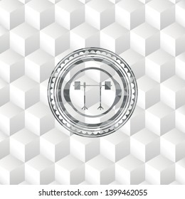 barbell on rack icon inside grey badge with geometric cube white background