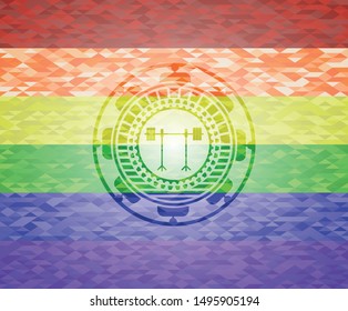 barbell on rack icon inside emblem on mosaic background with the colors of the LGBT flag