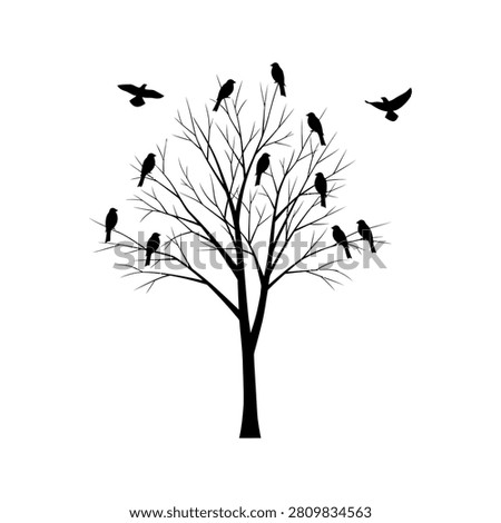 Bare tree silhouette with perched and flying black birds