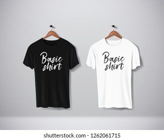 Basic Black and white short sleeve T-Shirts Mock-up clothes set hanging isolated on wall. Front side view with lettering for your design or logo. 