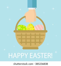 Basket with colorful Easter eggs in hand on blue background, illustration.