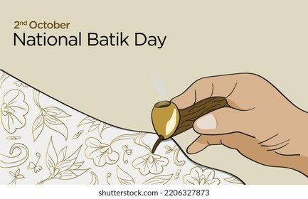 Batik making process, a hand holds canting - a vessel contains wax to outline the patterns drawing. 2nd October National Batik Day. 