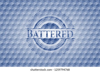 Battered blue emblem or badge with geometric pattern background.