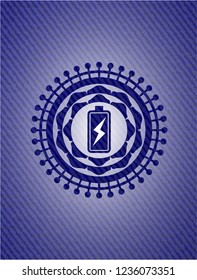 battery charging icon inside badge with denim background
