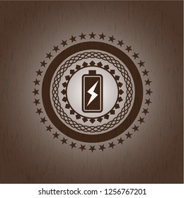 battery charging icon inside badge with wood background