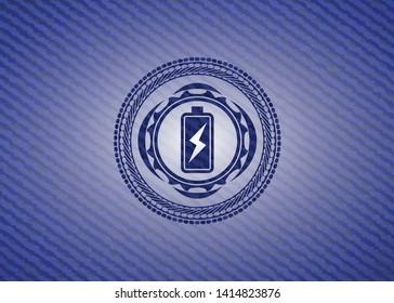 battery charging icon inside emblem with denim texture
