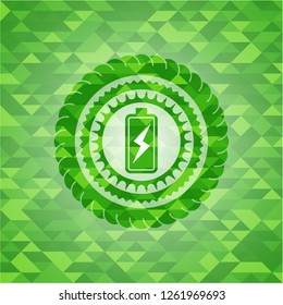 battery charging icon inside green emblem. Mosaic background