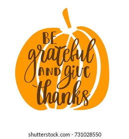 Be grateful and give thanks. Gratitude hand lettering quote and orange pumpkin isolated on white background.  Thankfulness phrase