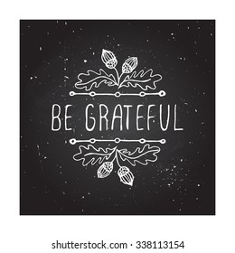 Be grateful. Hand sketched graphic vector element with acorns and text on chalkboard background.  Thanksgiving design.