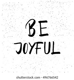Be joyful - brush script calligraphic design for Xmas greetings cards, invitations. Handwritten calligraphy on black subtle ink spotted texture background.
