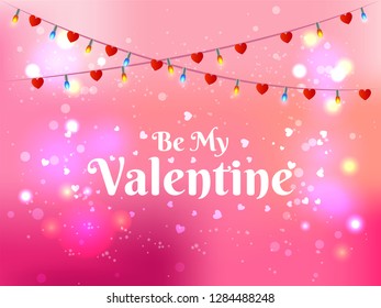 Be my valentine lettering on pink bokeh background decorated with light garlands and tiny hearts. Valentine's Day greeting card design.