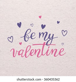 Be my Valentine for Valentines day card. Calligraphy lettering with hearts  on cardboard background. Love design concept.