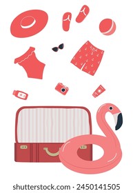 Beach accessories falling into red suitcase. Red swimsuit, swimming trunks, hat, sunglasses, flip flops, sunscreen, camera, flamingo swimming ring. Packing suitcase for summer vacation. Hello Summer