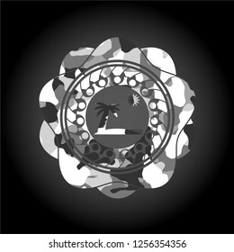 beach icon inside grey camouflage emblem