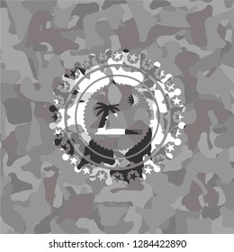 beach icon inside grey camouflaged emblem