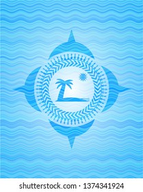 beach icon inside light blue water emblem background.
