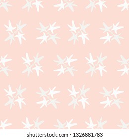 Beach sea star seamless pattern. Starfish form flower shapes repeating on a pale peach background. Great for wedding, spa or resort stationery, textiles, gift wrapping paper or product packaging.
