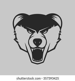 The bear bares its teeth. Animal head logo or icon in one color. Vector illustration.