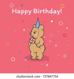 A bear cub in a festive cap is looking in the side and holding a big candy on a stick