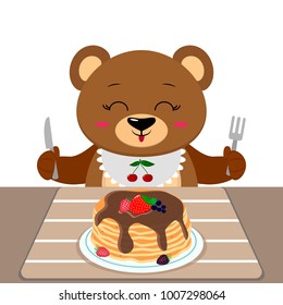 A bear is sitting at a table eating pancakes with chocolate and berries, isolated on a white background.