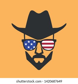 Bearded cowboy in sunglasses and in a hat. Cool American man