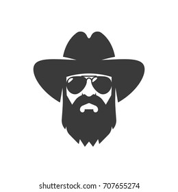 Bearded cowboy in sunglasses and in a hat. Cool American man