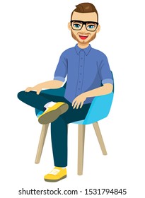 Bearded happy man with glasses in casual clothes sitting on chair