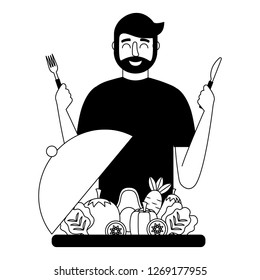 bearded man with fresh vegetables and fork knife