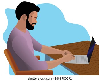 A bearded man work on a laptop at a desk