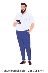 A bearded overweight man in a shirt and jeans stands writing a message on a smartphone