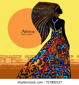 
Beautiful African woman in a bright dress against the background of a conventional African landscape