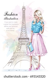 Beautiful blonde hair girl with hand bag. Fashion woman with eiffel tower on background. Hand drawn young woman in fashion clothes. Sketch. Vector illustration.