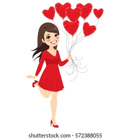 Beautiful brunette girl holding heart balloons celebrating Saint Valentine day wearing short red dress