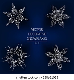 Beautiful decorative vector white winter snowflakes on a dark blue background. Calligraphic decorative elements.
