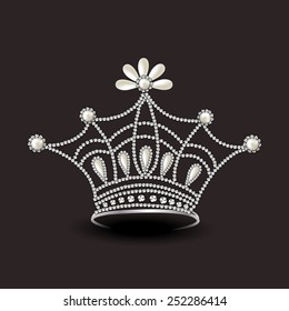 Beautiful diamond crown isolated on dark brown background.