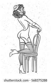 Beautiful female dancer wearing a cabaret style stocking, gloves, mask and lingerie. Posing standing on a vintage chair.