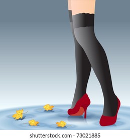 Beautiful female feet in stockings and shoes in the autumn with leaves