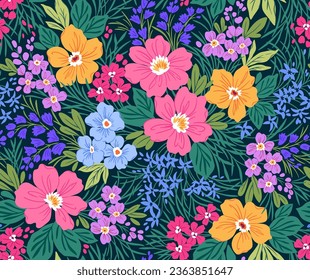 Beautiful floral pattern in small abstract flowers. Small bright colorful flowers. Dark blue background. Ditsy print. Floral seamless background. Liberty template for fashion prints. Stock pattern.