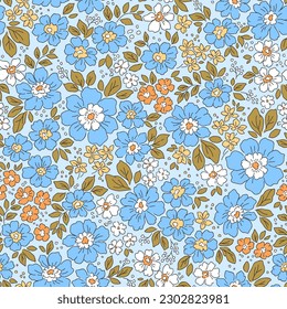 Beautiful floral pattern in small flowers. Small blue and orange  flowers. Light blue background. Liberty print. Floral seamless background. Trendy template for fashion prints. Stock pattern.