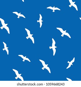 Beautiful flying seagulls in the blue sky seamless pattern