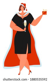A beautiful girl in a black dress with a slit holds a glass of champagne and a gift in a box. Christmas outfit isolated on white. Christmas celebration remotely.