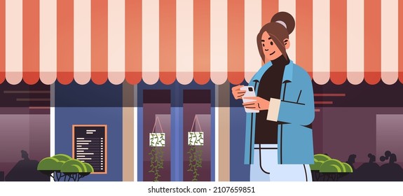 beautiful girl in casual clothes walking city street and using smartphone social media communication digital addiction