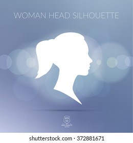 Beautiful girl head silhouette on blue grey blurred background with light spots. 