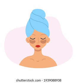 Beautiful girl with patches on her eyes and a towel on her head. The woman takes care of the skin of the face.