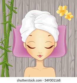 Beautiful girl relaxing in the spa on the wood background