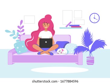 Beautiful girl sitting on a sofa at a laptop with a cat and pillows. Freelance concept. Home study