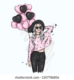 Beautiful girl in stylish clothes and balloons in the form of hearts. Valentine's Day and Love.