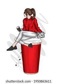 A beautiful girl in stylish clothes sits in a large glass of coffee. Fashion and style, clothing and accessories.