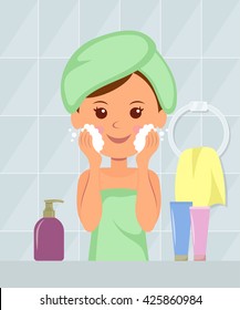 Beautiful girl with a towel on his head washes away makeup from the skin of her face foam. Taking care of your skin. Healthy lifestyle. Cosmetics.