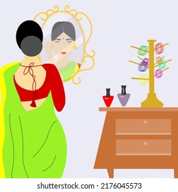 A beautiful Indian rural women with saree wearing earrings infront of mirror.